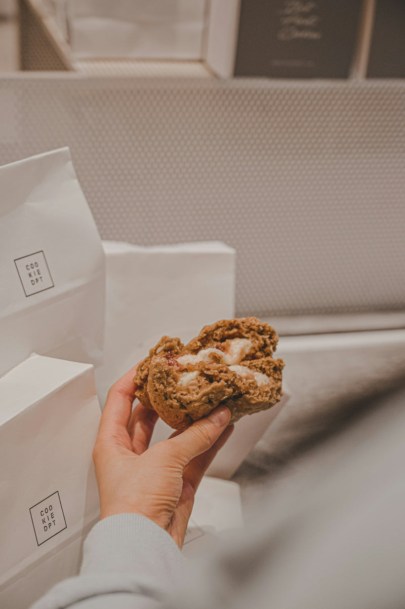 Cookie à la main devant un sac